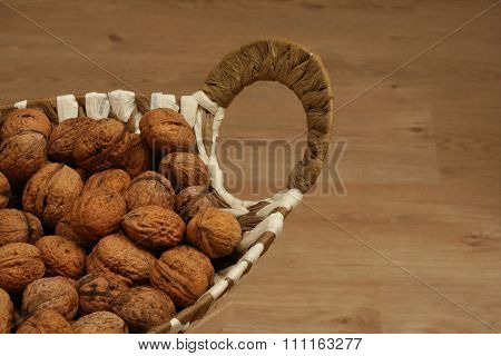 Basket full of walnuts on the wooden floor