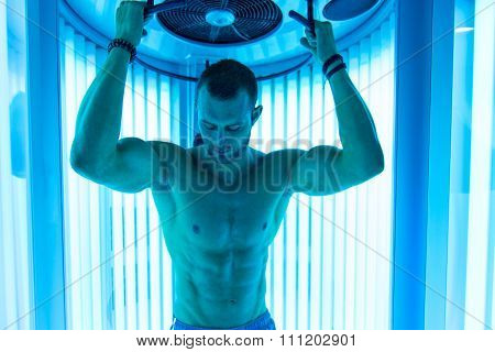Young Muscular Man At Solarium In Beauty Salon
