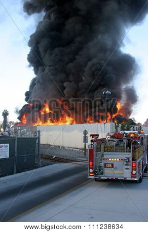 HARBOR GATEWAY, CALIFORNIA- DECEMBER 12, 2015: Fire erupts at recycling yard in Harbor Gateway. Flames and Acrid Black Smoke fill the air during a fire in Harbor Gateway, California Dec. 12, 2015
