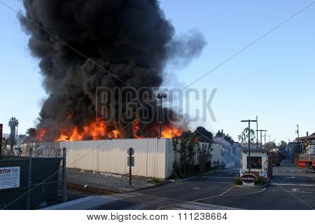 HARBOR GATEWAY, CALIFORNIA- DECEMBER 12, 2015: Fire erupts at recycling yard in Harbor Gateway. Flames and Acrid Black Smoke fill the air during a fire in Harbor Gateway, California Dec. 12, 2015