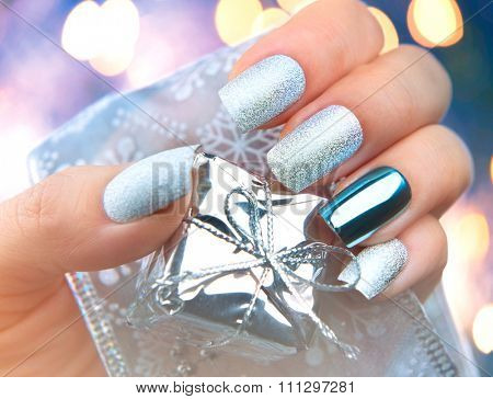 Christmas Nail art manicure. Winter Holiday style bright Manicure Design. Christmas decorations and snowflakes. Nail Polish. Beauty hands. Trendy Stylish Silver and Blue Colorful Nails, Nailpolish