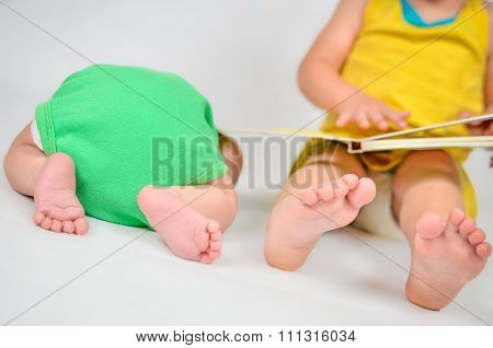 Little Girl Is Reading A Book Tog Her Baby Brother. Black And White Photo With Soft Focus On Their F
