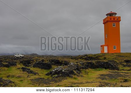 In front of orange lighthouse