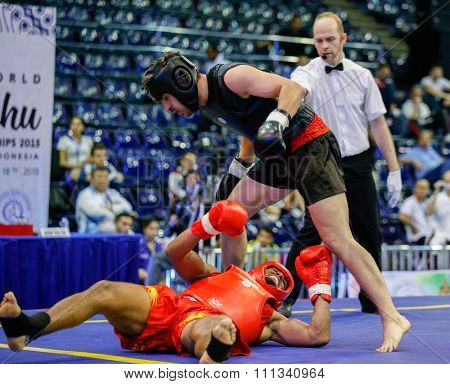 JAKARTA, INDONESIA - NOVEMBER 17, 2015: Reyel Bowen of Bermuda (red) fights Sandor Molnar of Hungary (black) in the men's 85kg Sanda event at the 13th World Wushu Championship 2015.