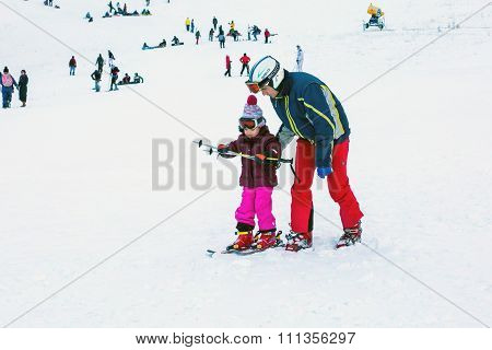 The child learning to ski and man on the slope in Bansko, Bulgaria