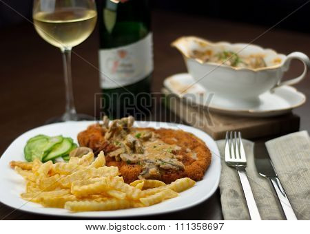 Schnitzel, French Fries, Cucumber Salat And White Wine With Jaeger Sauce