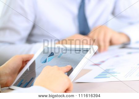 Business Colleagues Working And Analyzing Financial Graphs On A Digital Tablet