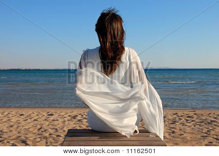 Donna seduta sulla spiaggia