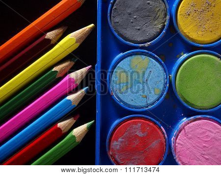 Pallette of water colors and colored pencils