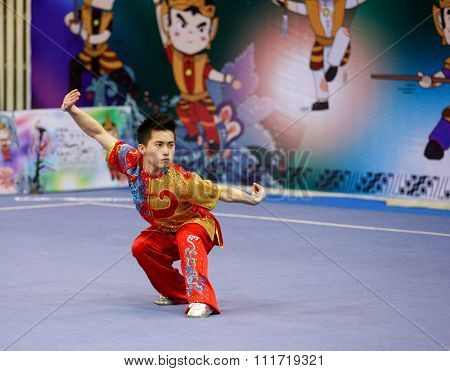 JAKARTA, INDONESIA - NOVEMBER 17, 2015: Wong Weng Son of Malaysia performs the movements in the men's Compulsory Changquan event in the 13th World Wushu Championship 2015 in Istora Senayan Stadium.