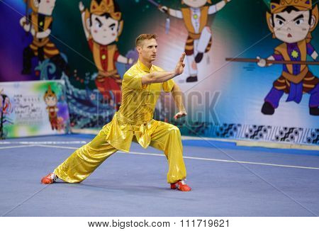 JAKARTA, INDONESIA - NOVEMBER 17, 2015: Justin Benedik of the USa performs the movements in the men's Compulsory Changquan event at the 13th World Wushu Championship 2015 in Istora Senayan Stadium.