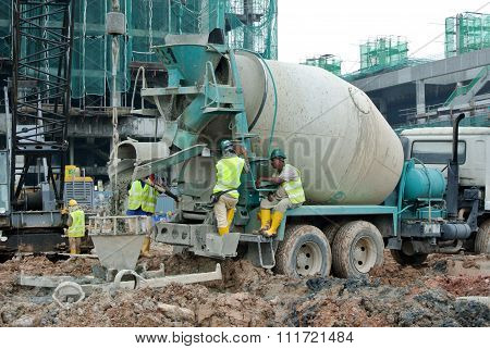 A concrete bucket receiving concrete from concrete truck