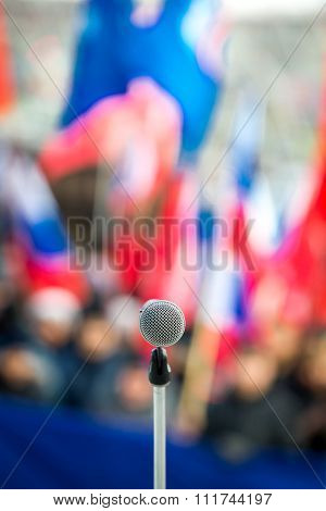 Microphone with bright blurred flags on the background
