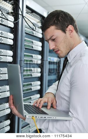 Businessman With Laptop In Network Server Room
