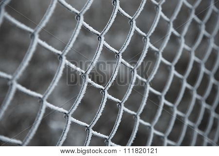 Frozen wire fence in winter frost