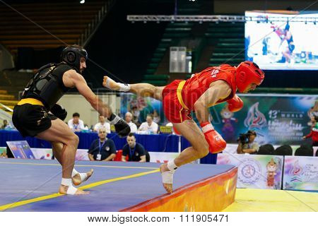 JAKARTA, INDONESIA - NOVEMBER 18, 2015: Nicholas Evagorou of Great Britain (red) fights Amir Fazli of Iran (black) in the men's 85kg Sanda event at the 13th World Wushu Championship 2015.