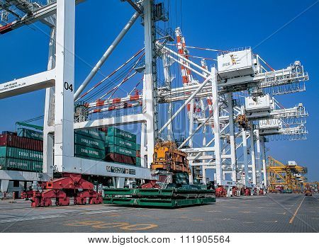 Crane moving containers in port shipyard in to ship
