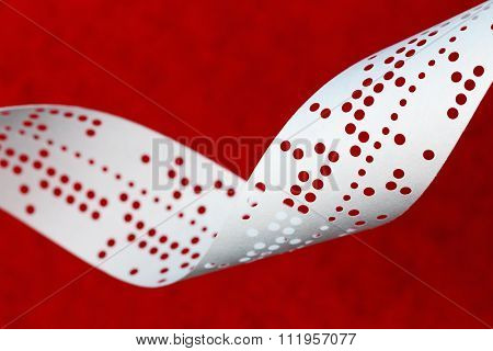 Closeup Of Perforated Punched Tape On Blue Background