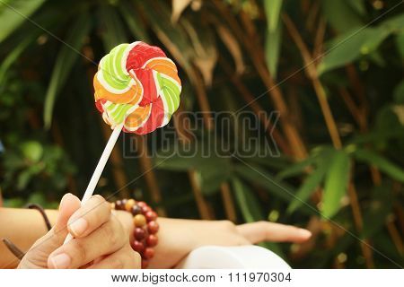 Young Woman Holding Candy At The Park.