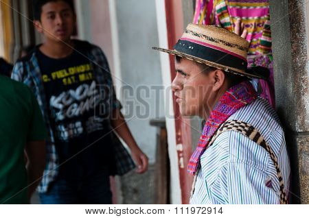 Man Wearing A Native Hat Leaning on a Cemented Pillar