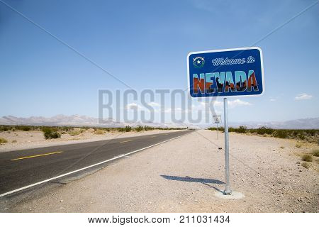 A sign by the side of the road welcoming visitors to Nevada