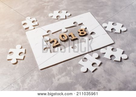 New Year Concept 2018. Jigsaw Puzzle On Grey Concrete Background.