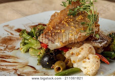 Fried white fish fillets with cauliflower and broccoli with pepper and olives and beans