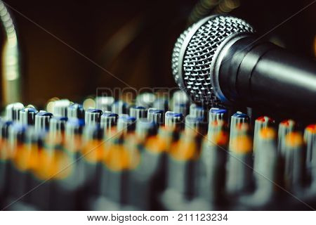 the microphone rests on an audio mixer