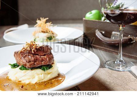 mashed potato with meat on a white plate in a restaurant