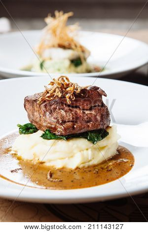 mashed potato with meat on a white plate in a restaurant