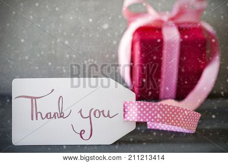 Label With English Calligraphy Thank You. Pink Gift Or Present With Gray Cement Background With Snowflakes