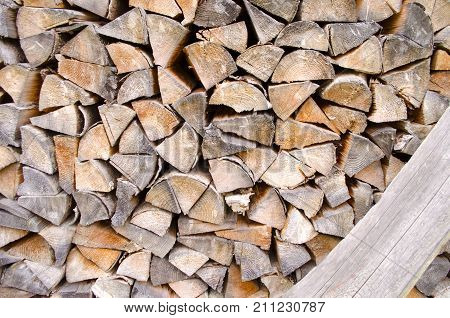 Background of splitted dried and stacked firewood. Bunch of wood.