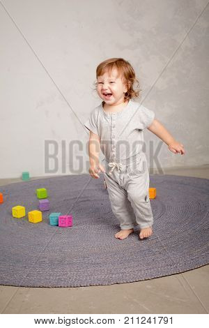 Little happy girl playing with toy on floor. Kindergarten.