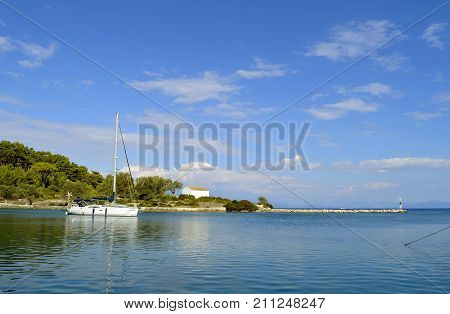 A white yacht sailing out of Antipaxos harbour a small island south of Corfu