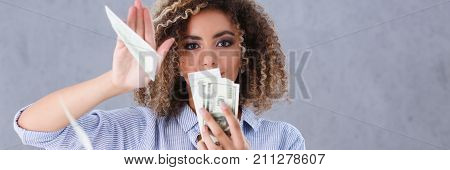 Beautiful woman portrait. Scattering money notes dollars in fashion vows style  curly hair with white locks eye view of the camera