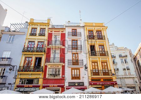 VALENCIA, SPAIN - August 19, 2017: Colorful buildings with cafes and restaurants near the food market in Valencia city, Spain