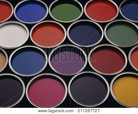 CANS OF COLOURED PAINT IN A VARIETY OF COLOURS