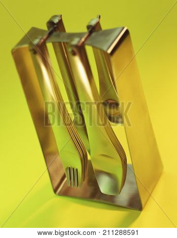 STAINLESS STEEL CUTLERY ON YELLOW AND GREEN BACKGROUND