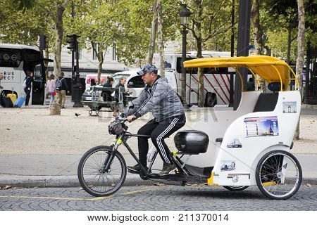 French people biking bicycle rickshaw waiting travelers use service tour around paris city at Place Charles de Gaulle road on September 6 2017 in Paris France