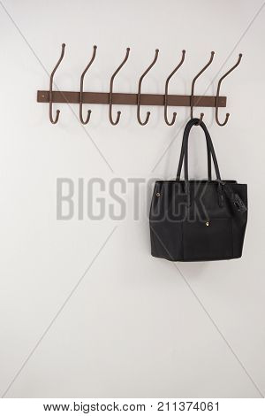 Black bag hanging on hook against wall