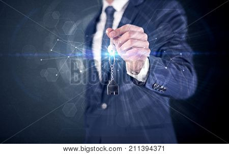 Businessman in suit holding over a key with connection concept around