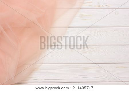 Beautiful layers of gentle pink background with tulle fabric on a wooden background