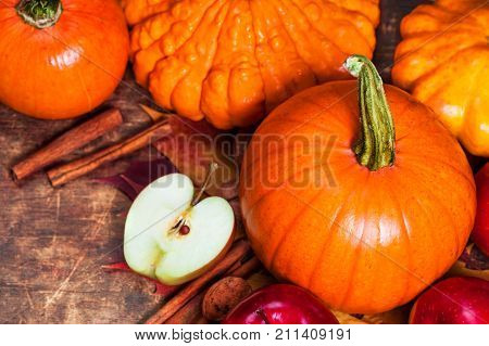 Harvest or Thanksgiving background with pumpkins apples and fallen leaves on wooden background with copyspace. Halloween Thanksgiving day or seasonal autumnal concept