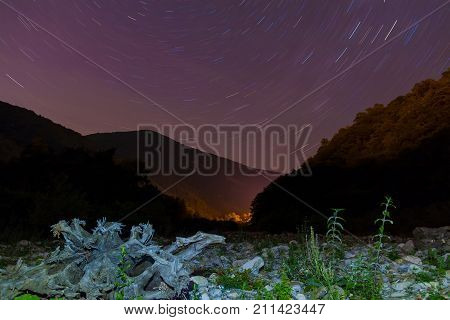 Long exposure photo of night landscape of ravine mountains and star trails Sochi Russia