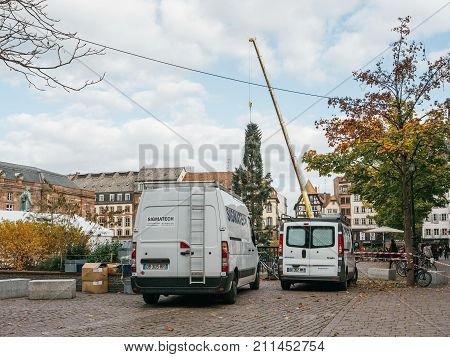 STRASBOURG FRANCE - OCT 30 2017: SWhite vans in Strasbourg Christmas Tree Install in central Place Kleber Square by gigantic crane for the upcoming winter holidays