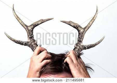 A cheating wife. Her husband has grown horns. Concept on a white background.