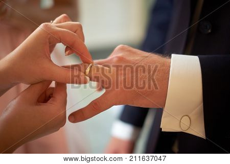 wedding, dressing wedding ring on finger close-up