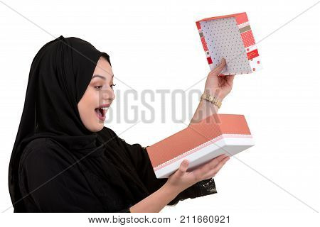 Happy young muslim woman with shopping bag and gift boxes isolated over white background.