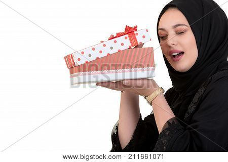 Happy young muslim woman with shopping bag and gift boxes isolated over white background.
