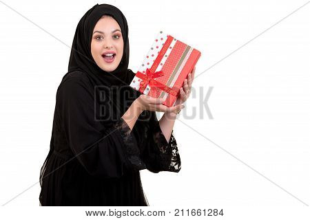 Happy young muslim woman with shopping bag and gift boxes isolated over white background.